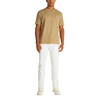 Person wearing a beige t-shirt and white pants on a white background